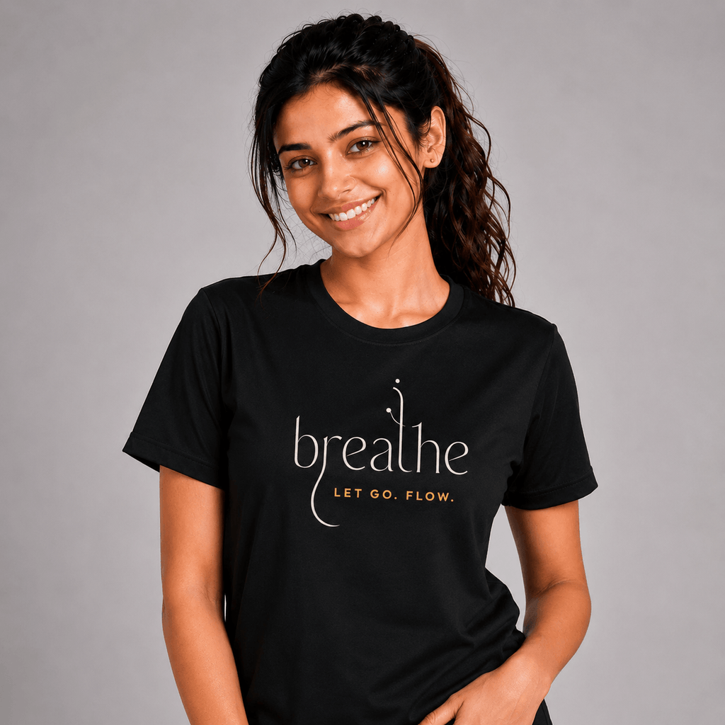 Woman wearing a black yoga t-shirt with 'breathe LET GO. FLOW.' text on a gray background
