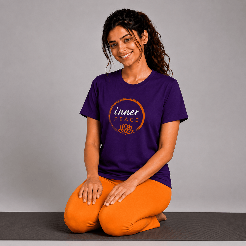 Woman wearing a purple 'inner peace' yoga t-shirt and orange pants on a gray background