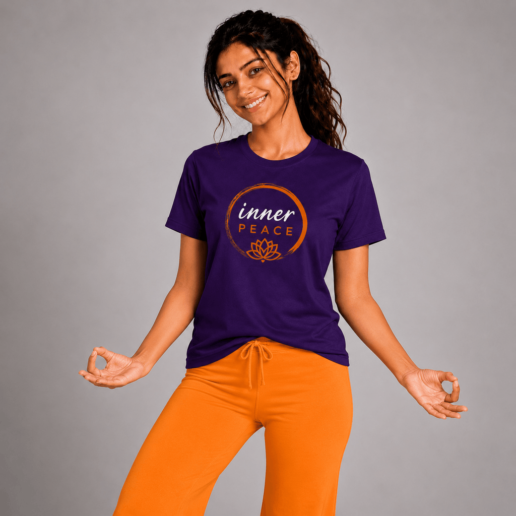 Woman wearing a purple 'inner PEACE' yoga t-shirt and orange pants on a gray background