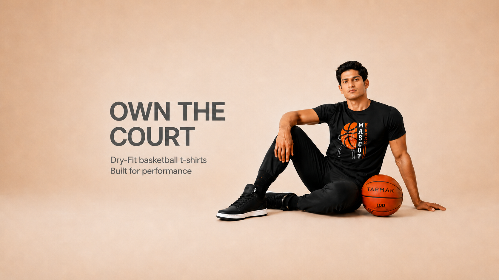 Man sitting on the ground with a basketball, wearing a dry-fit basketball t-shirt, on a beige background.