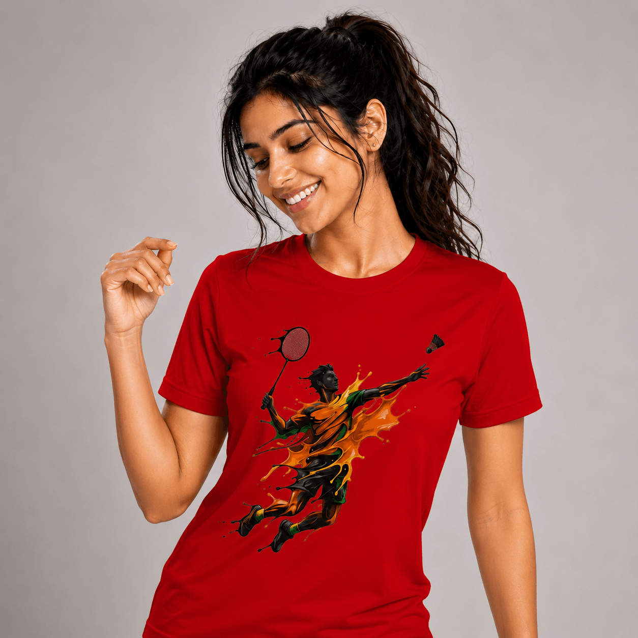 Woman wearing a red badminton t-shirt with a graphic design on a gray background