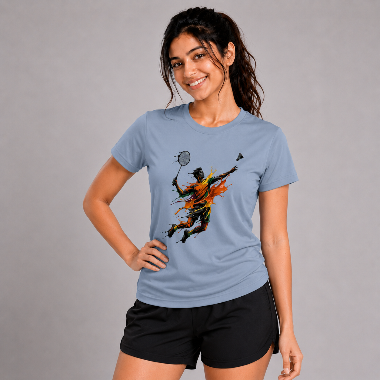 Woman wearing a blue t-shirt with a graphic design on a gray background