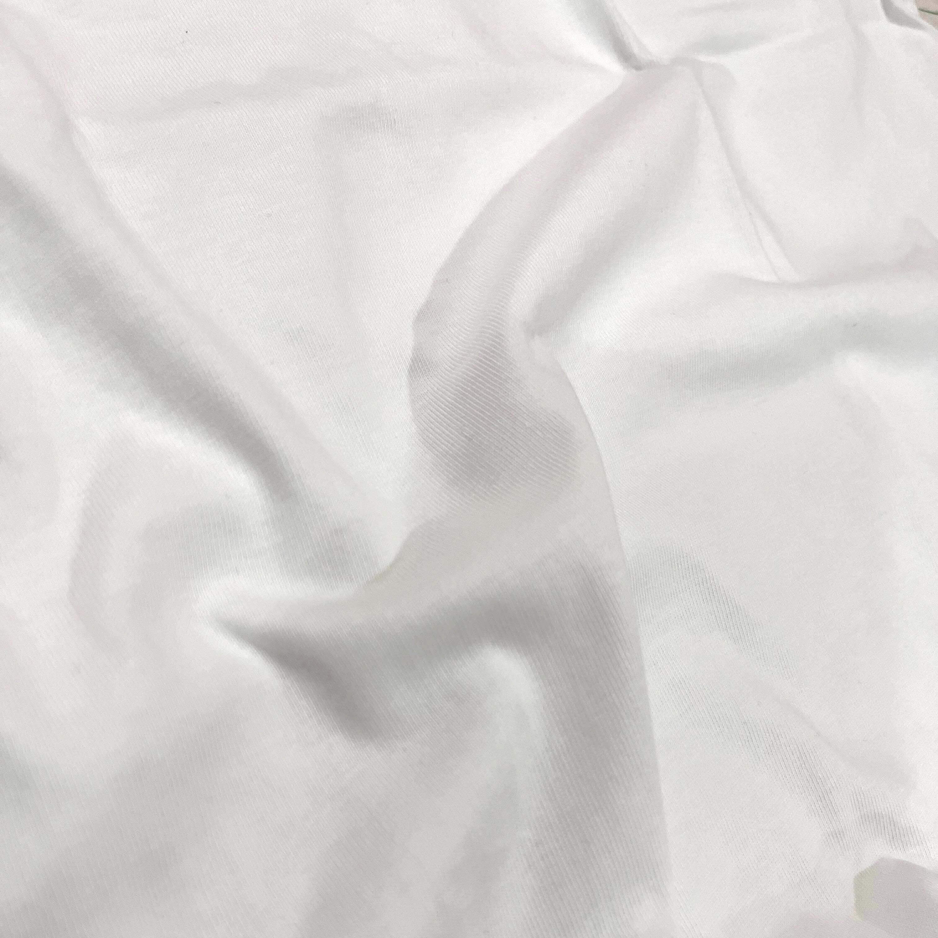 A close-up of draped white fabric with soft folds and a smooth texture.