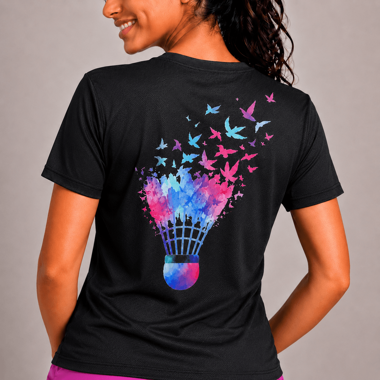 Person wearing a black t-shirt with a colorful badminton shuttlecock design on the back.