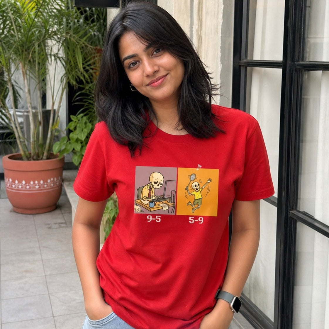 Person wearing a red t-shirt with a graphic design, standing outdoors.